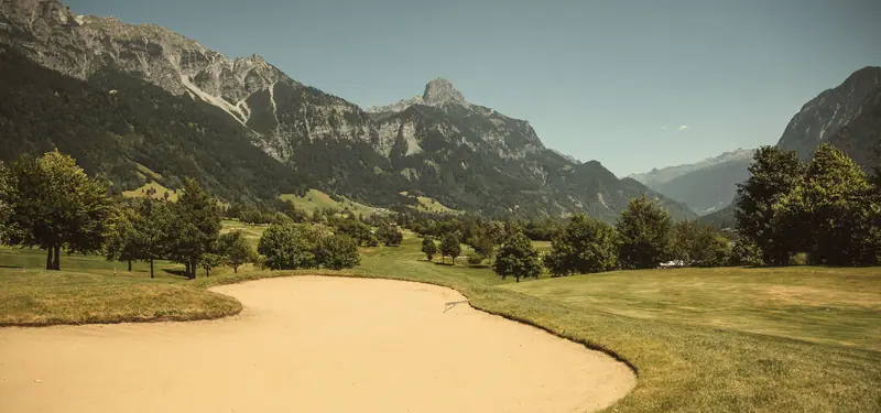 Fairwaybunker vor schroffen Gipfeln