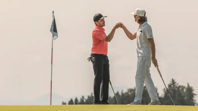 Zwei Golfer klatschen an der Fahne ab